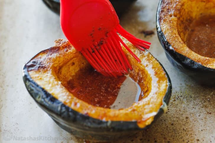 Brushing maple roasted acorn squash with butter