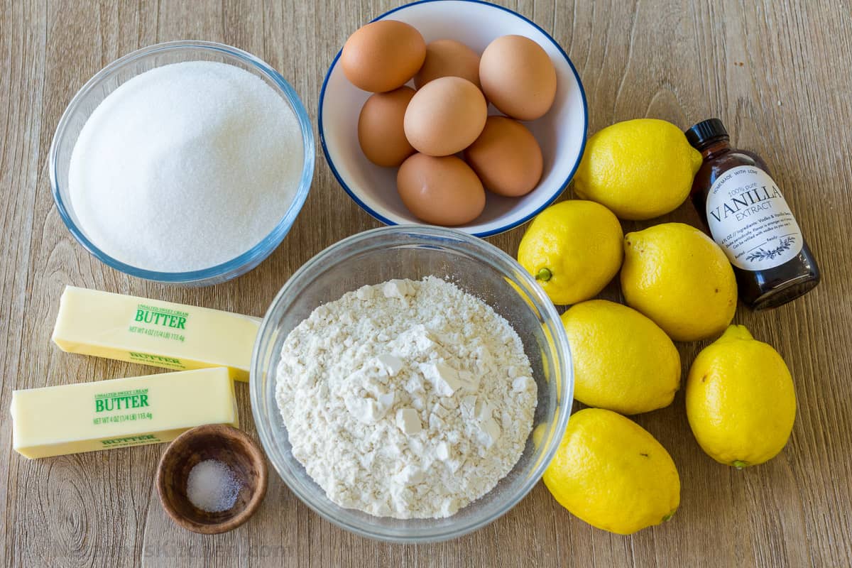 Ingredients for making lemon bars with lemons, eggs, flour, butter, sugar, vanilla, and salt