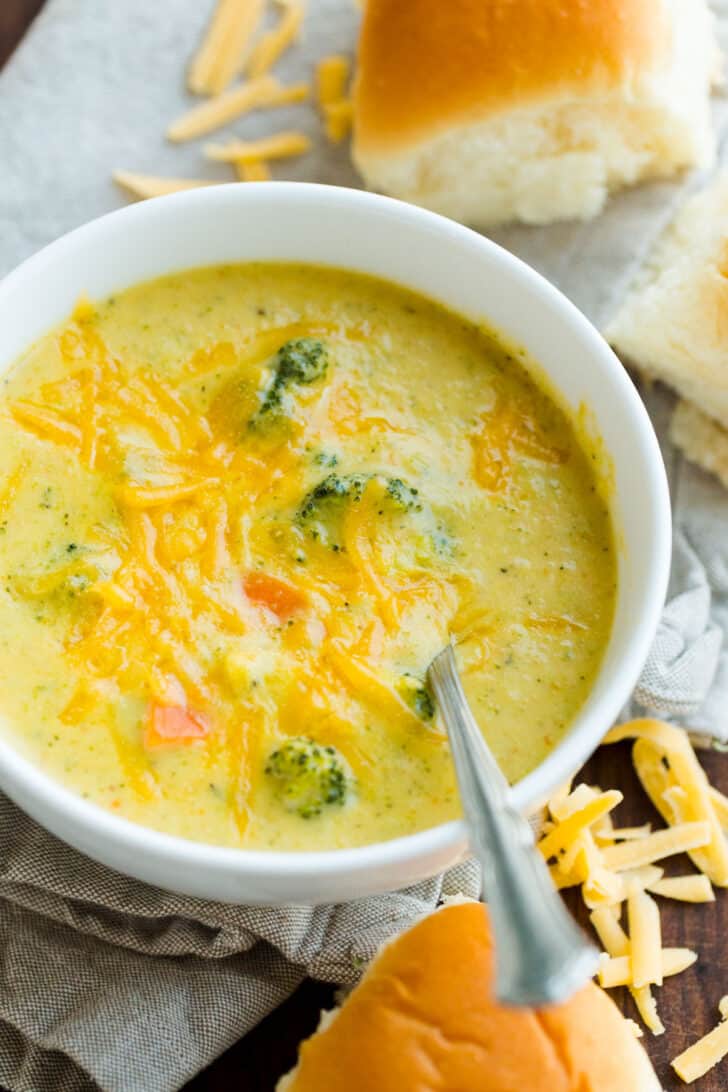 Panera Copycat soup recipe in a bowl with a spoon served with dinner rolls
