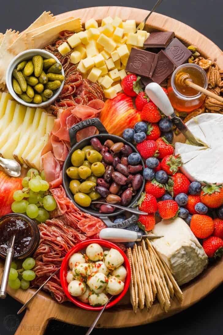 how to build a charcuterie board with cheeses, meats, condiments, pickled ingredients, fruit and nuts