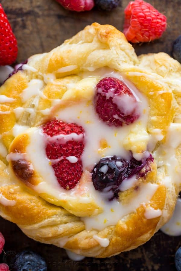 Close-up of cheese danish with lemon glaze and berries, showcasing the puff pastry dessert recipe's texture
