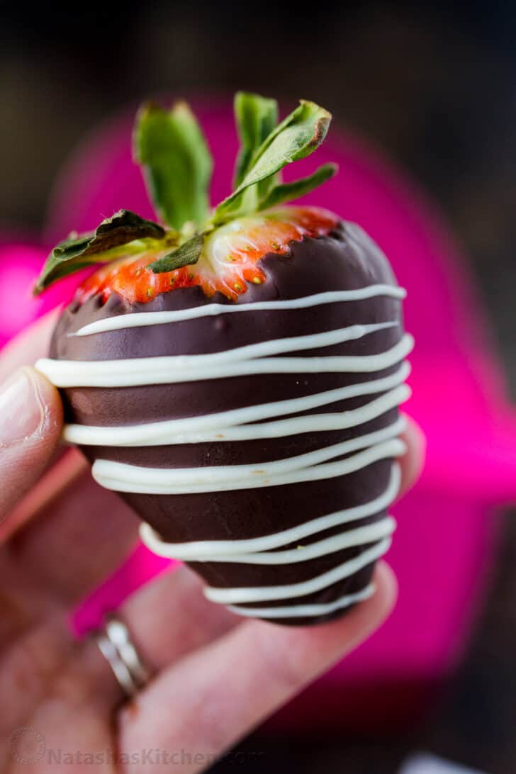 Fraise trempée dans du chocolat brillant avec une décoration en chocolat blanc