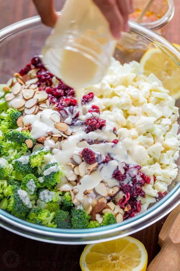 Arrosage de la salade de brocoli et de chou-fleur avec une vinaigrette crémeuse