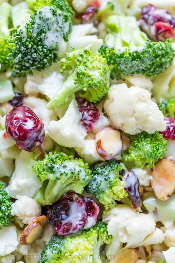 Up close tossed broccoli cauliflower salad coated with creamy honey dressing