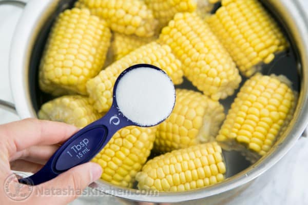 Adding sugar to our boiled corn on the cob for perfect sweet ears of corn