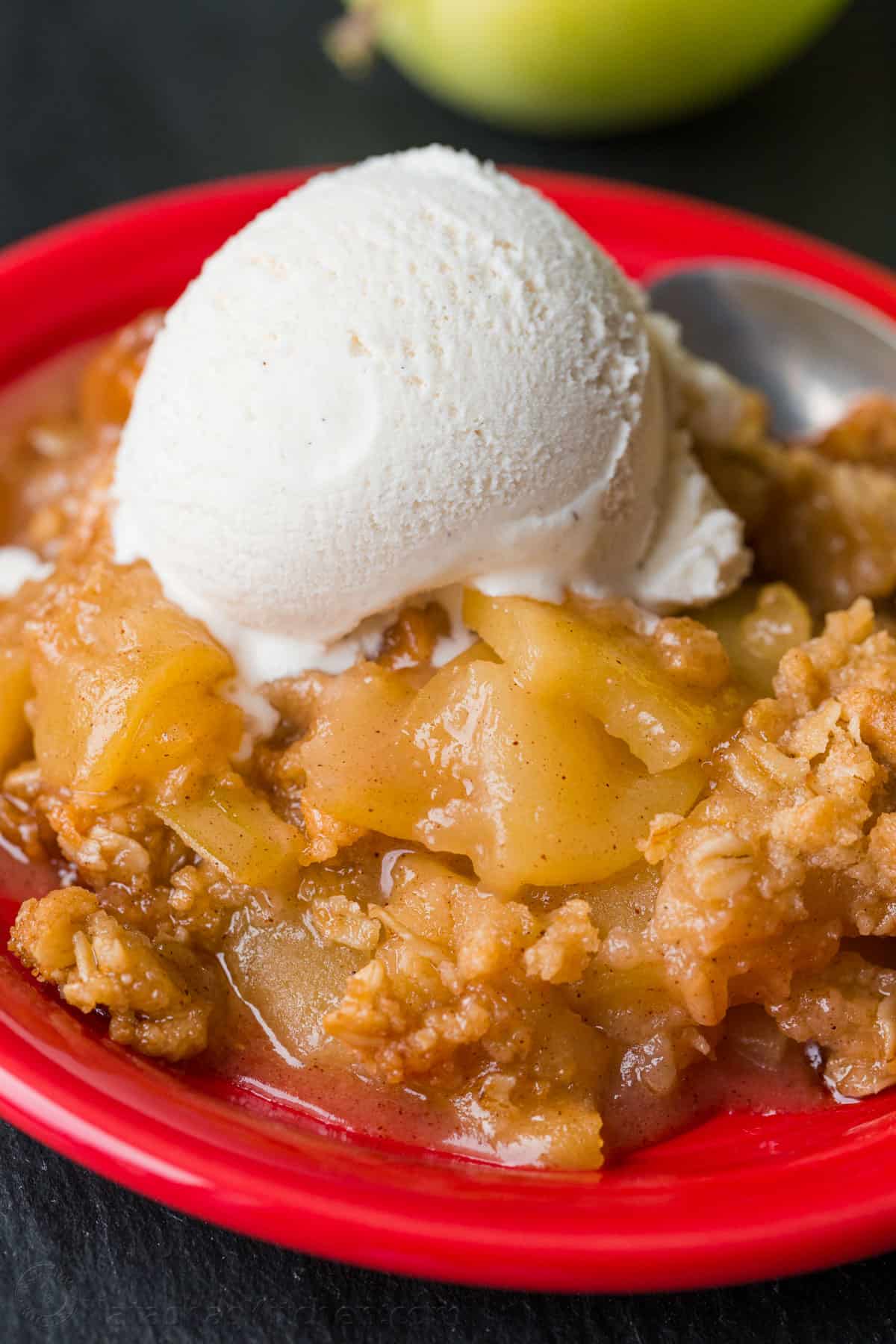 Plated apple crisp with apples, topping and vanilla ice cream