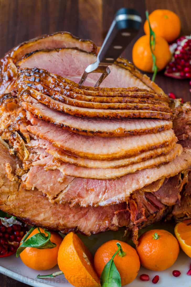 Glazed baked ham on a platter spiral sliced and ready to serve with apricot honey glaze