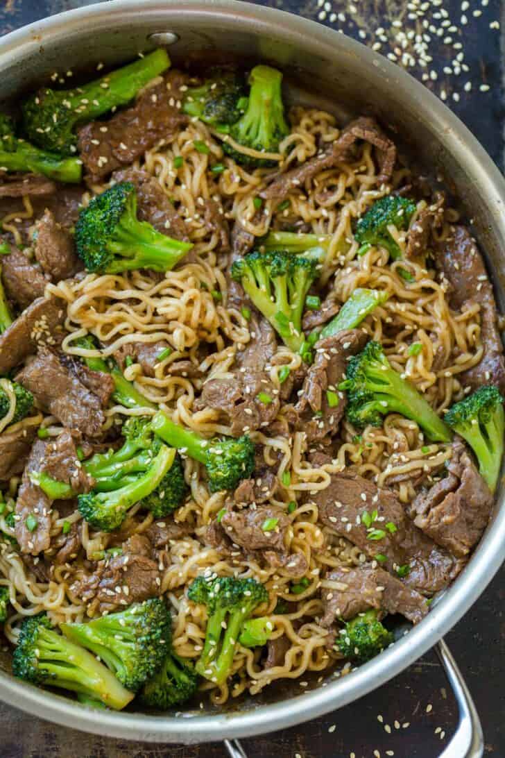 Beef and Broccoli ramen stir fry in skillet garnished with sesame seeds