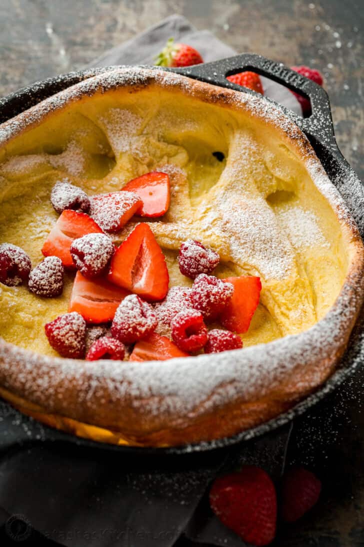 Dutch baby topped with fruit and powdered sugar