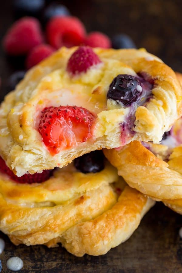Stacked berry cheese danishes glazed with lemon glaze and showing the inside of the cheese danish puff pastry recipe