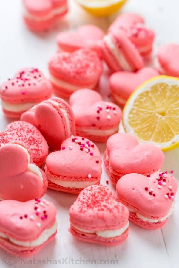 Heart Macarons are easier than you think! Heart-shaped macarons with tangy-sweet lemon buttercream. Includes video tutorial + free printable heart template! | natashaskitchen.com