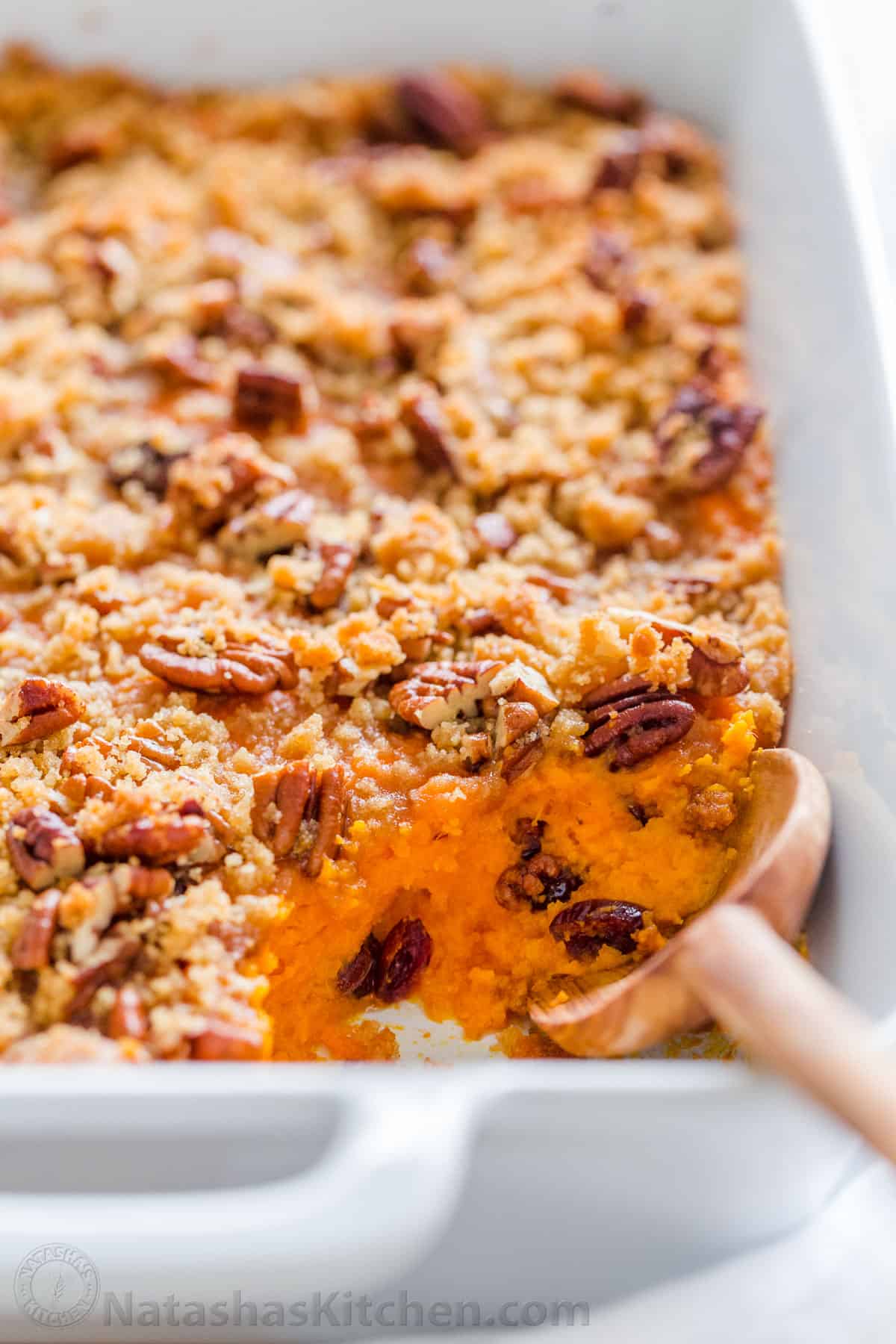 Sweet potato casserole recipe with pecan streusel topping with serving spoon 